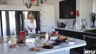 Katie Morgan is cleaning the kitchen while the guys are watching a game