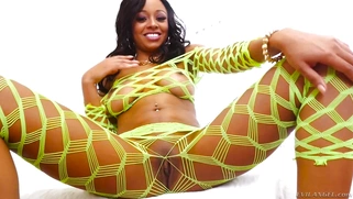 Anya Ivy posing in a neon fishnet ensemble that shows off her natural curves
